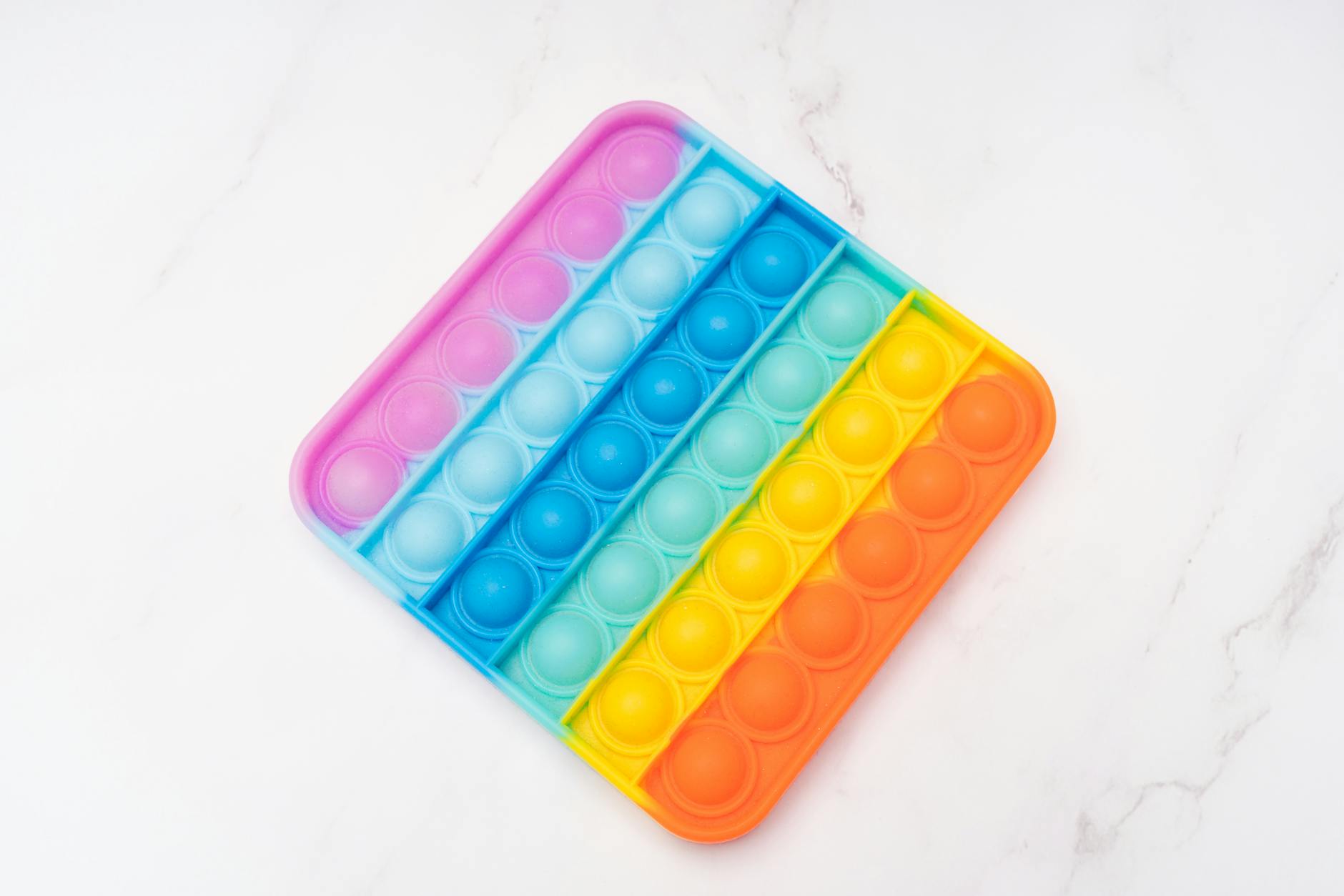 Kolorowa silikonowa zabawka Pop It w kształcie prostokąta na białym tle