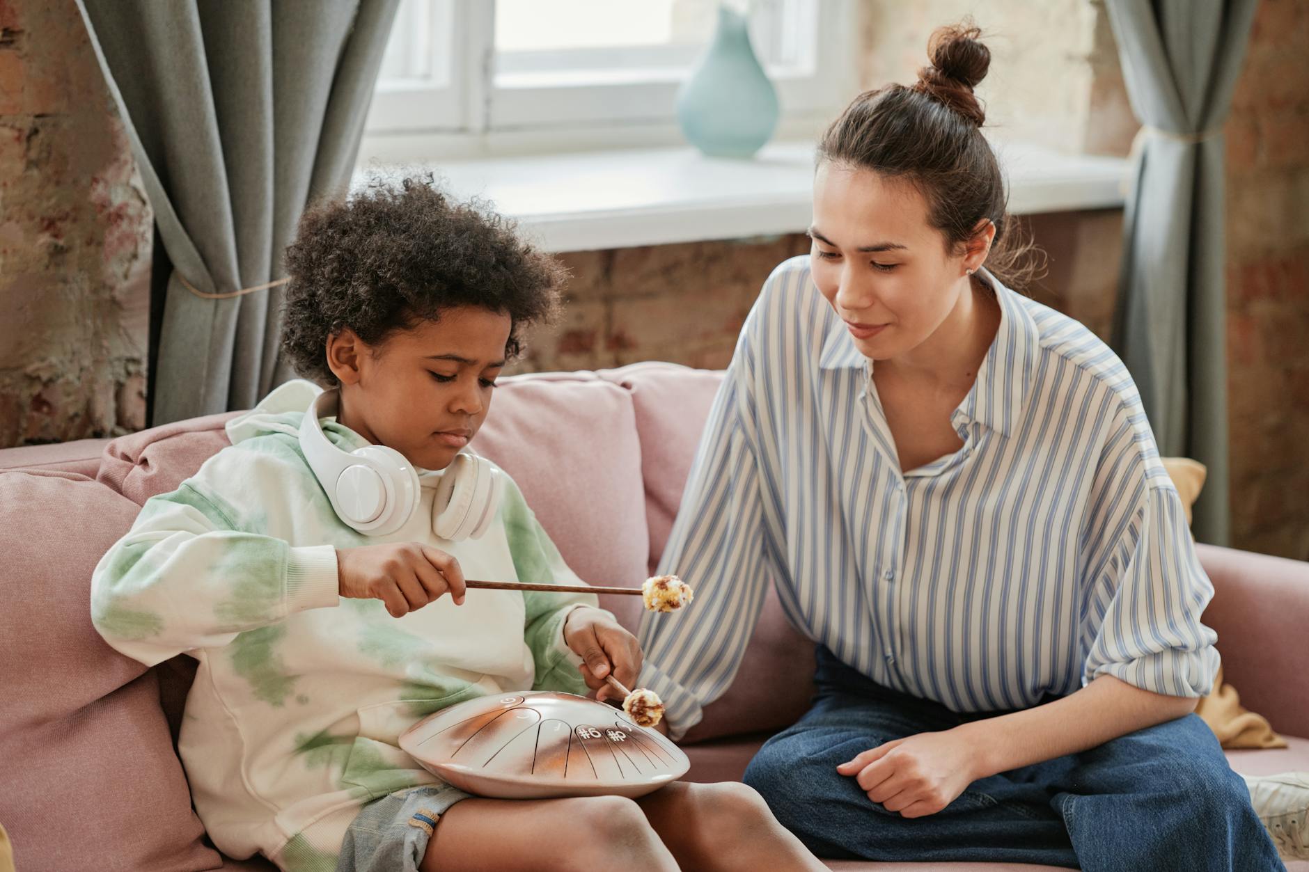 Mama z dzieckiem grają razem na instrumencie w domu