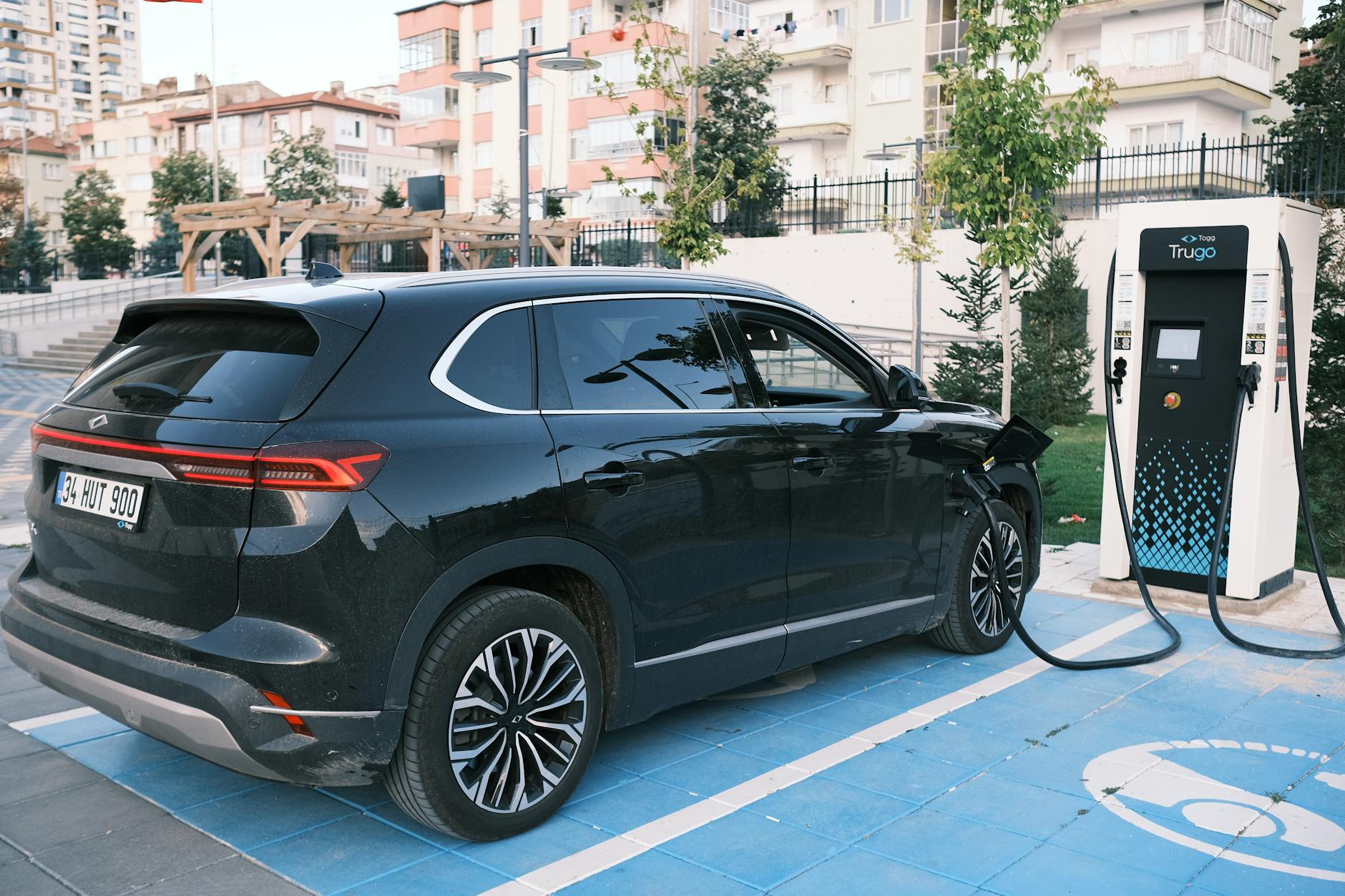Elektryczny SUV ładuje się na stacji, symbol nowej motoryzacji