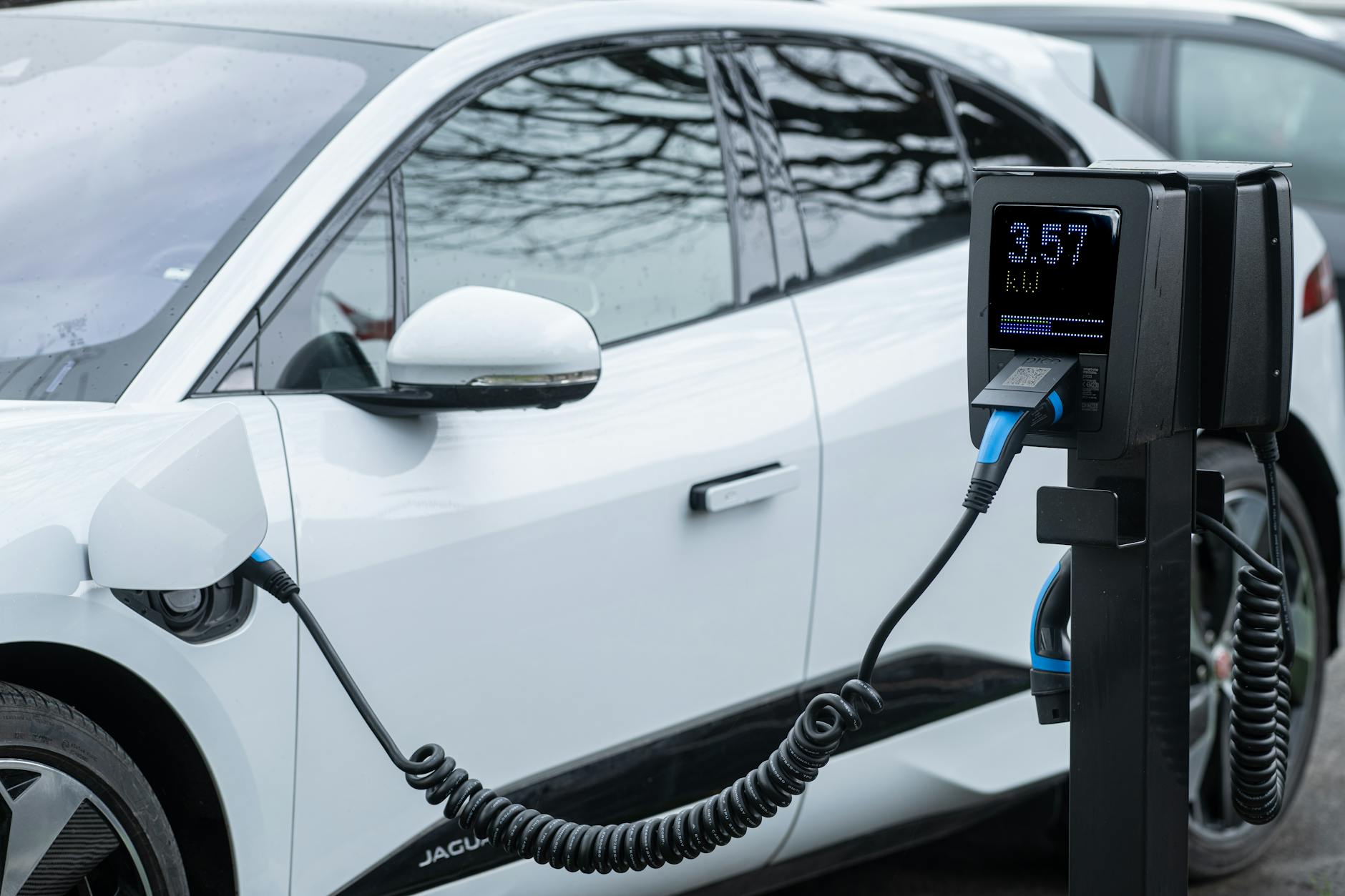 Zbliżenie na elektrycznego SUV-a ładowanego przy stacji